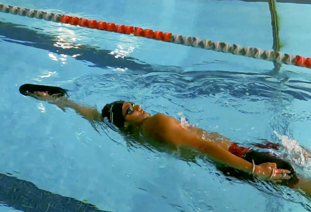 A 16-year-old swimmer using Rip Current Sports' Dual Boards in backstroke. 